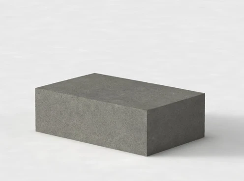 Pojedynczy bloczek betonowy w kształcie prostopadłościanu na jasnym tle